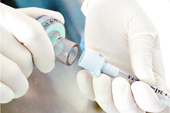Connecting medical breathing apparatus Medical professional with gloves connecting a breathing circuit filter to an endotracheal tube in a sterile environment.